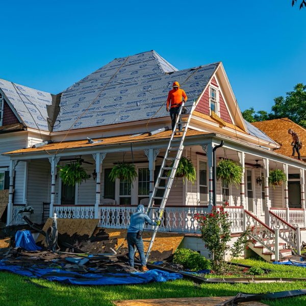 contractors replacing an old home's roof