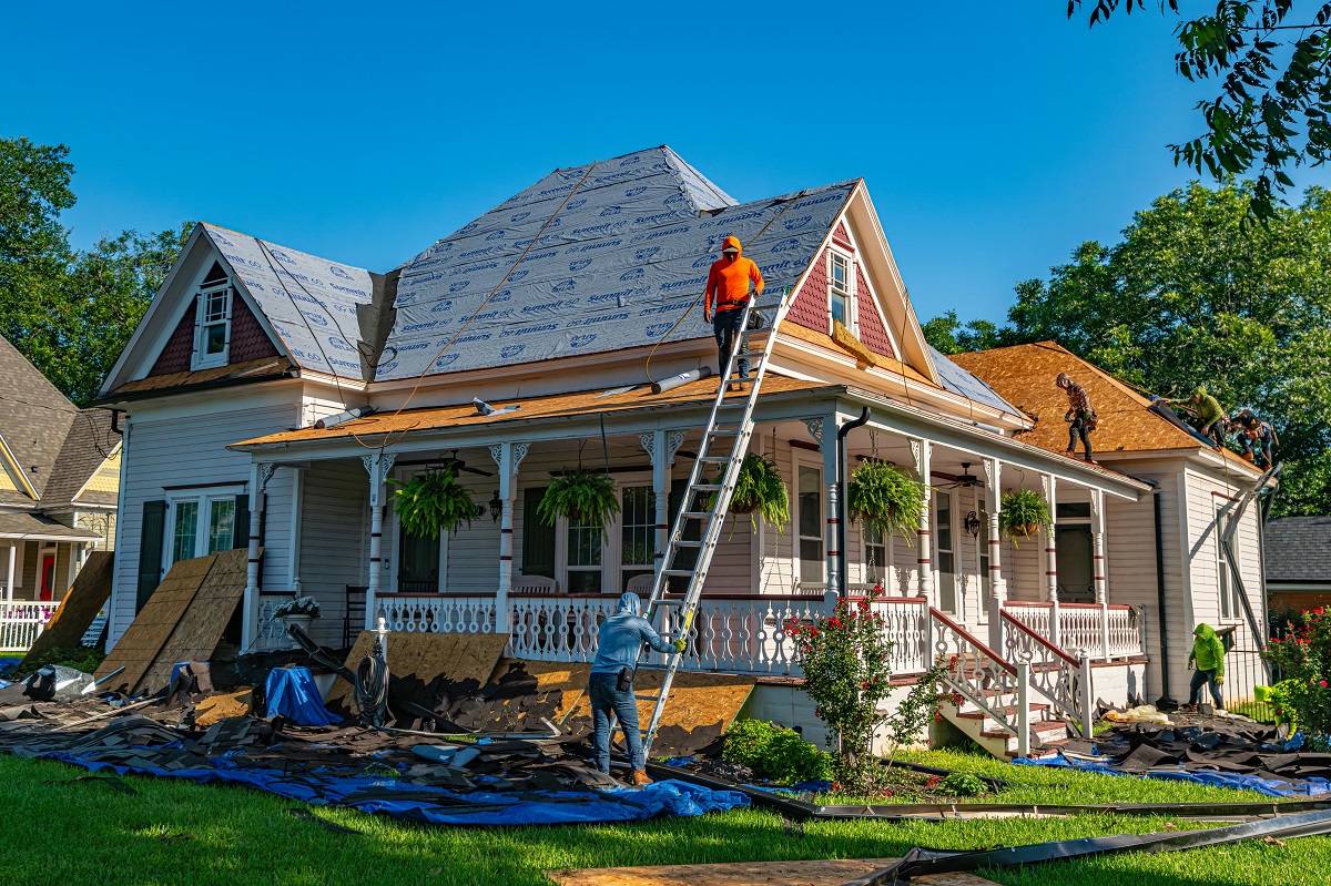 contractors replacing an old home's roof